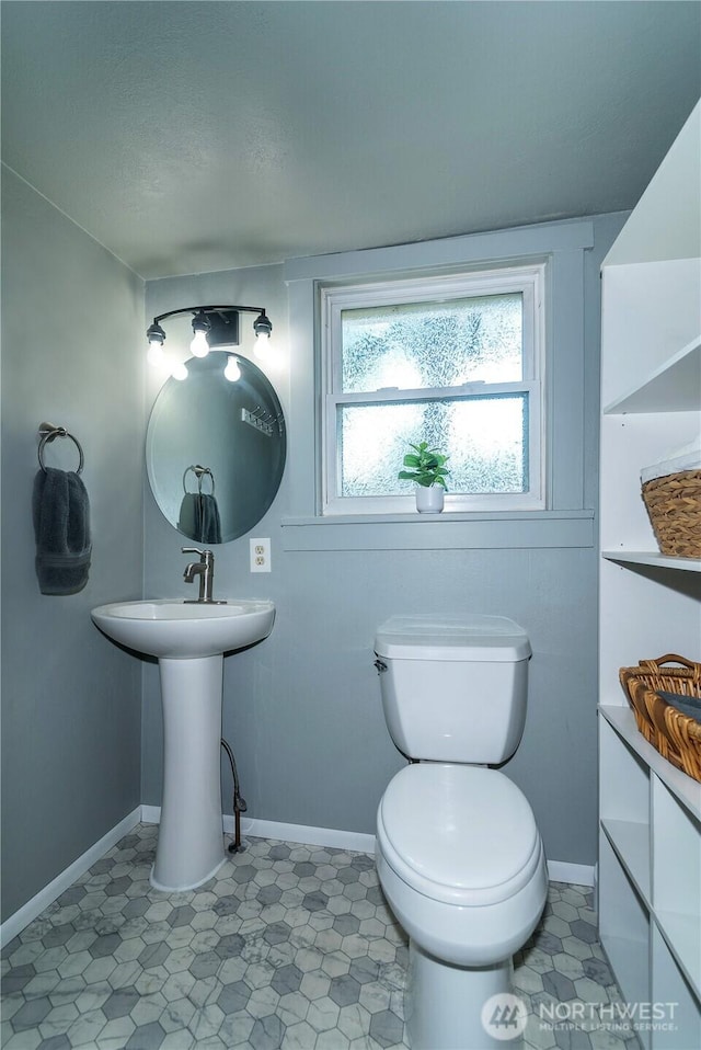 bathroom featuring toilet and baseboards