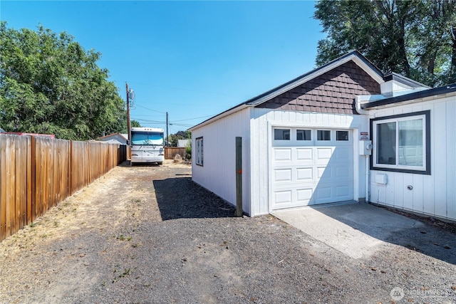 exterior space with an attached garage, fence, and driveway