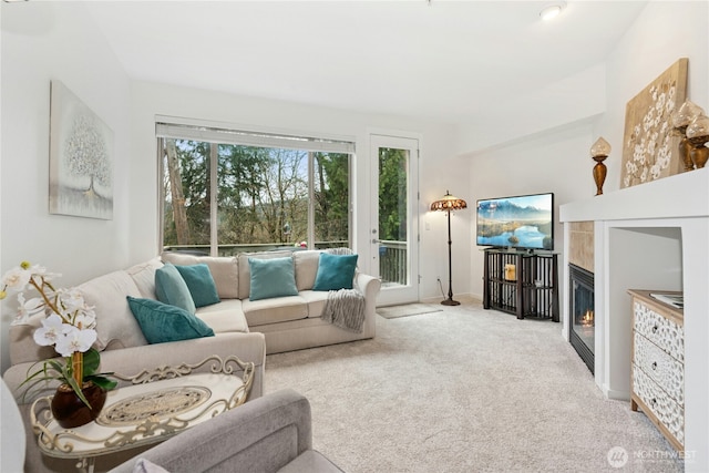 carpeted living room with a glass covered fireplace