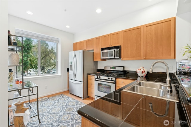 kitchen featuring a sink, dark countertops, recessed lighting, and stainless steel appliances