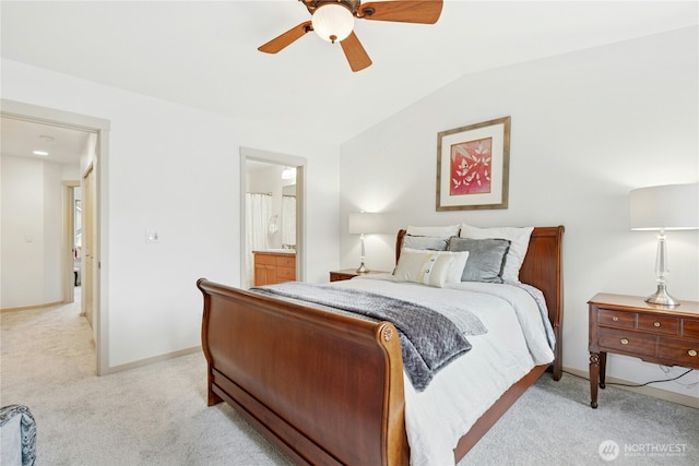 bedroom featuring baseboards, lofted ceiling, ceiling fan, ensuite bathroom, and light colored carpet