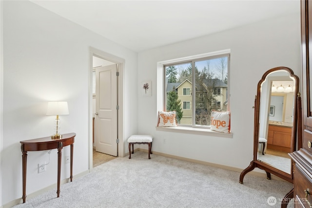 sitting room featuring light carpet and baseboards