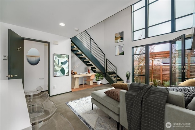 living room featuring stairway, recessed lighting, and a towering ceiling