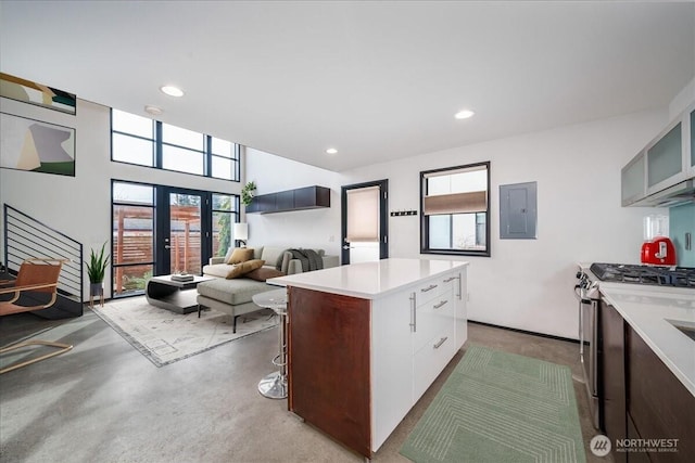 kitchen with gas stove, electric panel, recessed lighting, light countertops, and a center island