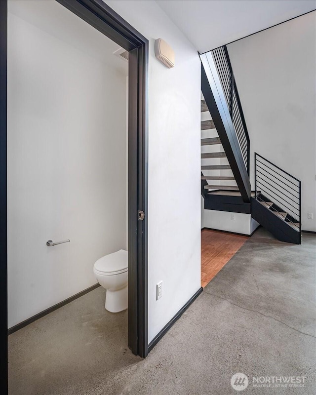 bathroom featuring baseboards and toilet