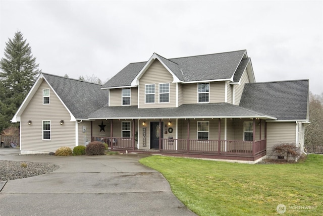 farmhouse-style home with covered porch, driveway, a shingled roof, and a front yard