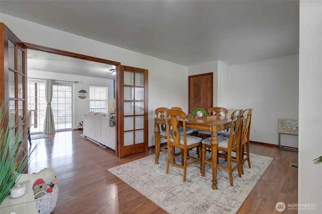 dining area with baseboards and wood finished floors