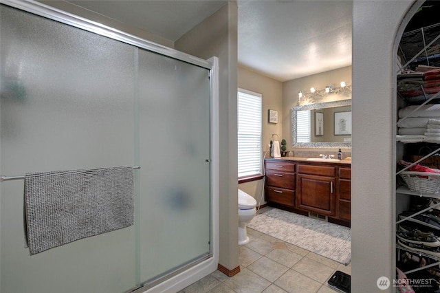 full bathroom with toilet, a stall shower, vanity, and tile patterned flooring