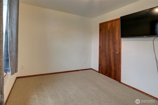 unfurnished bedroom with a closet, baseboards, and carpet floors