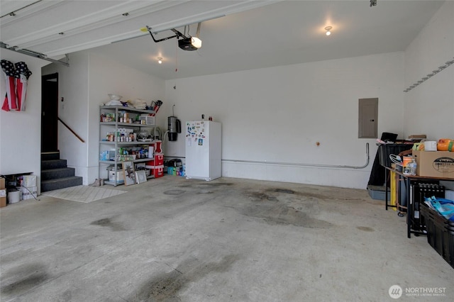 garage with electric panel, a garage door opener, and freestanding refrigerator