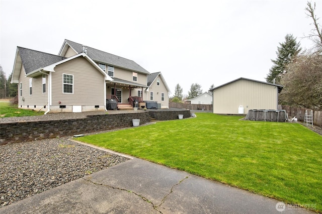 back of house with fence and a lawn