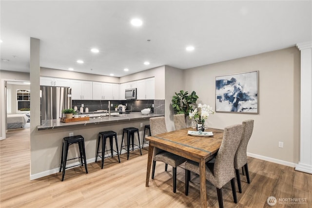 dining area with recessed lighting, light wood-type flooring, and baseboards