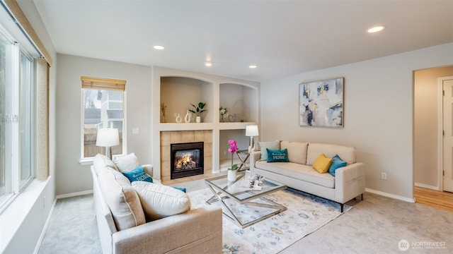 living room featuring recessed lighting, baseboards, light colored carpet, and a fireplace