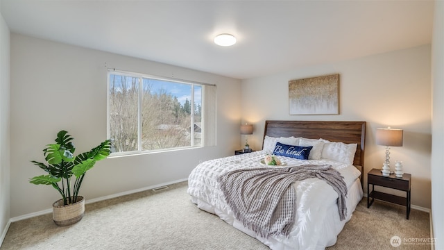 bedroom featuring visible vents, baseboards, and carpet