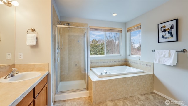 bathroom featuring a bath, a stall shower, and vanity