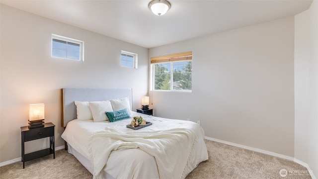 bedroom featuring light colored carpet and baseboards