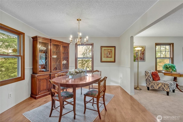 dining space featuring plenty of natural light, light wood-style floors, and a chandelier