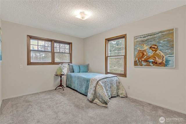 bedroom with baseboards, multiple windows, carpet, and a textured ceiling