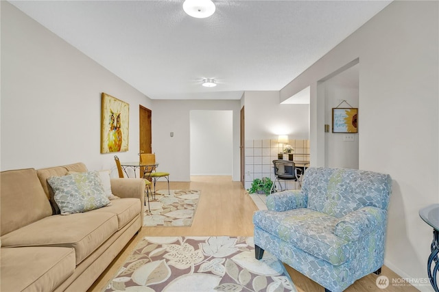 living area with baseboards and wood finished floors