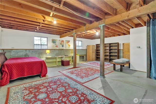 bedroom with a wainscoted wall and concrete flooring