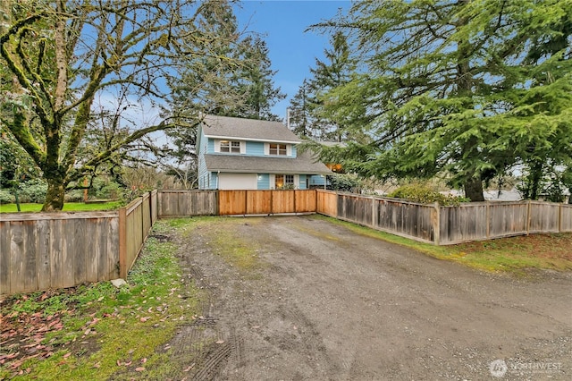 view of front facade featuring driveway and fence