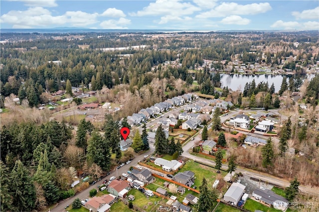 birds eye view of property with a forest view, a water view, and a residential view