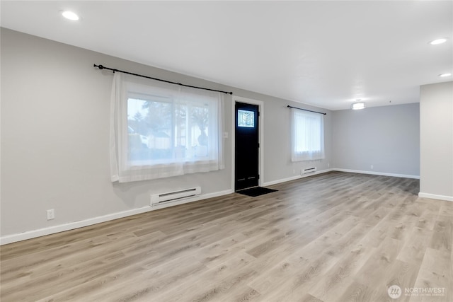 unfurnished room with baseboard heating, recessed lighting, baseboards, and wood finished floors