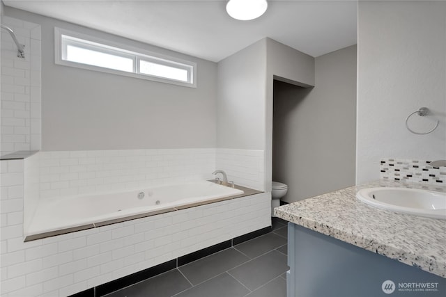 bathroom with tile patterned floors, toilet, a bath, and vanity