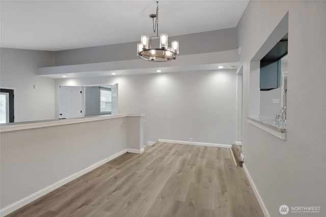 unfurnished dining area with a chandelier, recessed lighting, baseboards, and wood finished floors