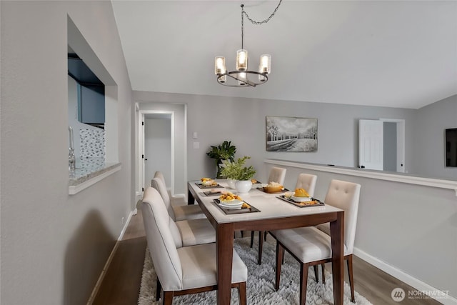 dining room featuring an inviting chandelier, baseboards, and wood finished floors