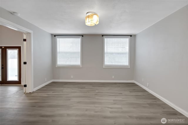 empty room with french doors, baseboards, and wood finished floors