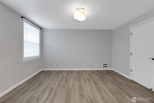 unfurnished room featuring visible vents, baseboards, and light wood-style flooring