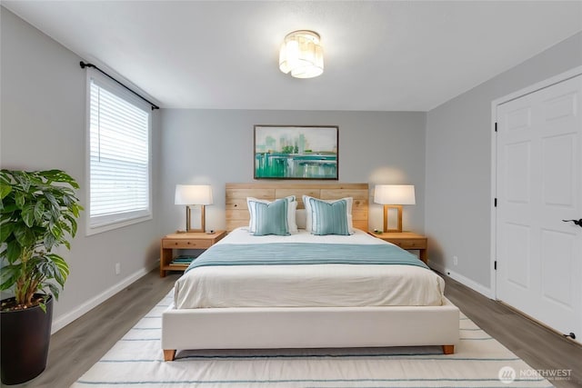 bedroom featuring wood finished floors and baseboards