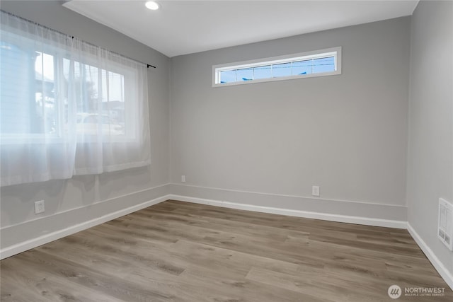 spare room with visible vents, recessed lighting, baseboards, and wood finished floors