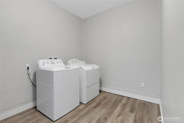 laundry area featuring light wood-type flooring, baseboards, independent washer and dryer, and laundry area