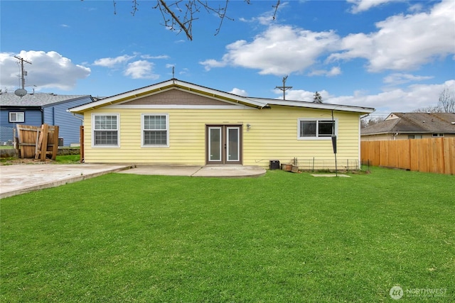 back of property with a patio area, fence, a lawn, and french doors