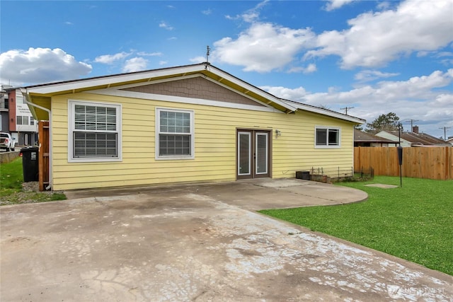 rear view of house featuring a yard, a patio area, french doors, and fence