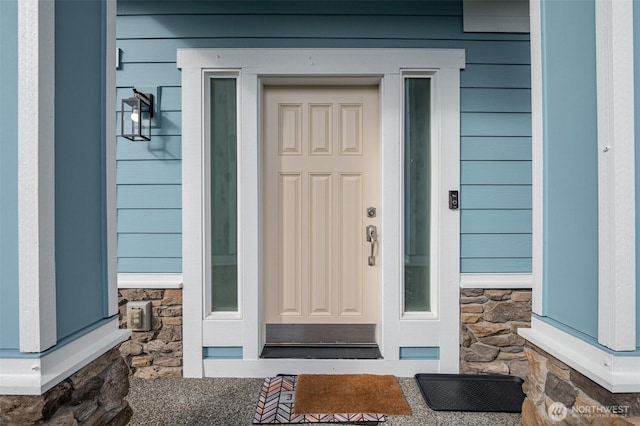 doorway to property featuring stone siding