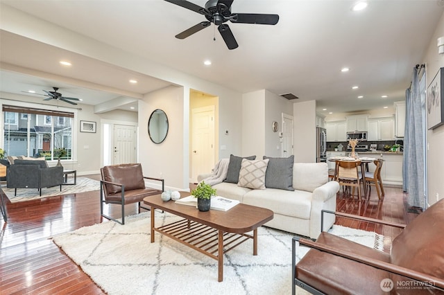 living area featuring hardwood / wood-style floors, recessed lighting, visible vents, and baseboards