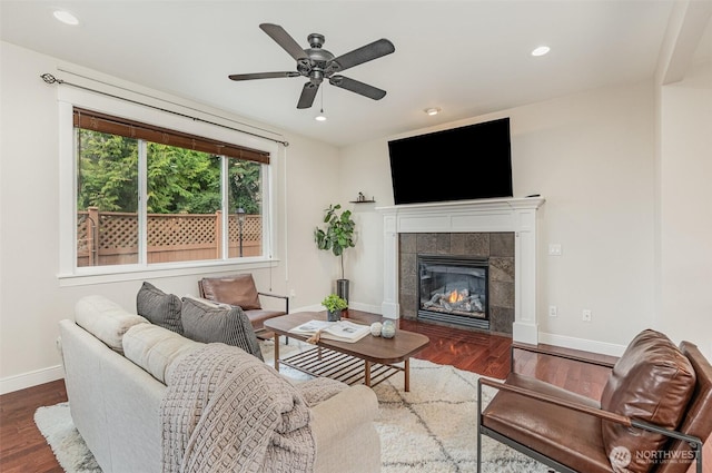 living area with recessed lighting, wood finished floors, baseboards, and a tile fireplace