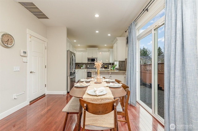 dining space featuring hardwood / wood-style floors, recessed lighting, baseboards, and visible vents