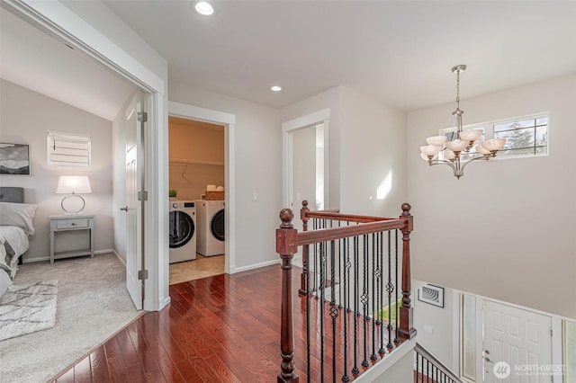 corridor with dark wood-style floors, an inviting chandelier, recessed lighting, washer and dryer, and an upstairs landing