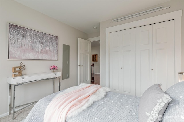 bedroom featuring carpet flooring, electric panel, baseboards, and a closet