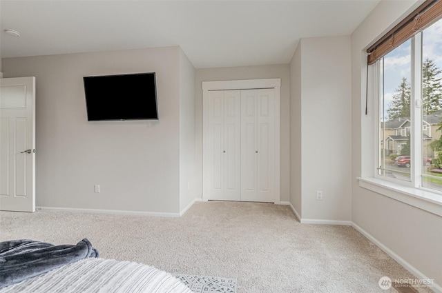 unfurnished bedroom with carpet, baseboards, and a closet