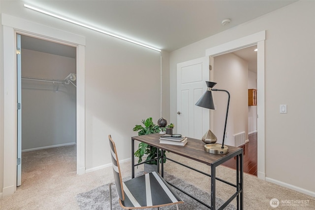 office space with baseboards, light carpet, and visible vents