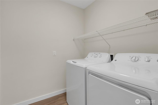 laundry room with washer and clothes dryer, laundry area, baseboards, and wood finished floors