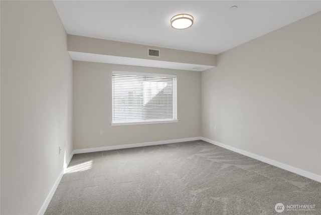 carpeted empty room featuring baseboards and visible vents