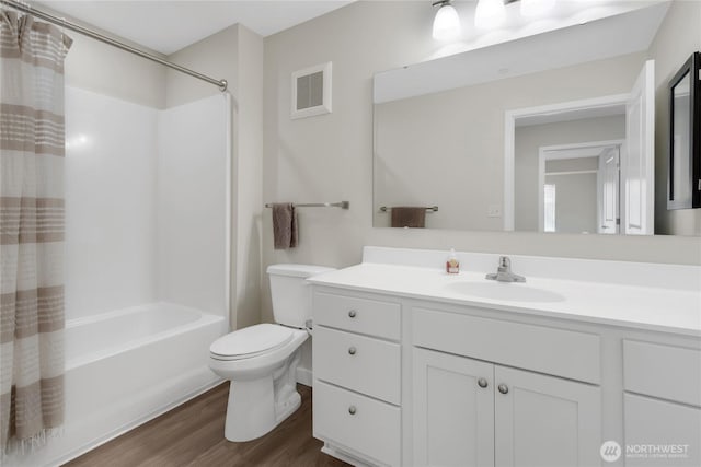 full bathroom with visible vents, toilet, shower / tub combo, wood finished floors, and vanity