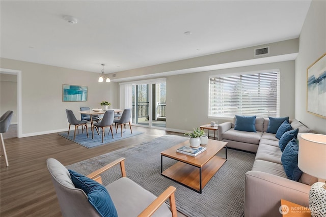 living room with visible vents, baseboards, and wood finished floors