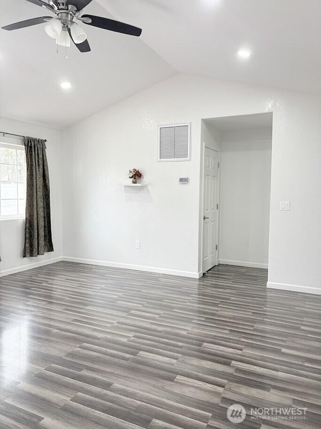 spare room featuring visible vents, baseboards, lofted ceiling, and wood finished floors